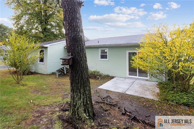 rear view of property featuring a patio and a lawn