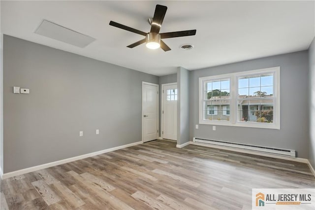 unfurnished room featuring light wood finished floors, visible vents, baseboards, baseboard heating, and a ceiling fan