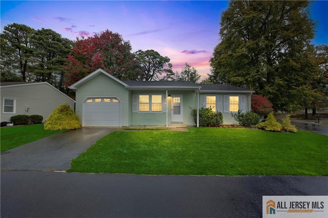 single story home with a yard, a garage, and driveway