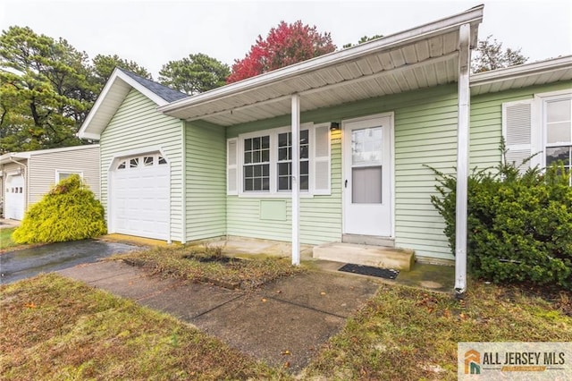 property entrance with a garage and driveway