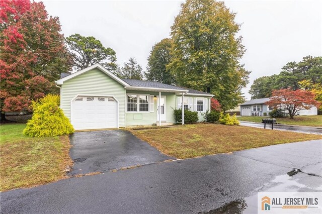 ranch-style house with a garage and a front lawn