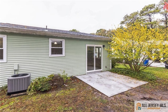 rear view of house with central AC unit and a patio area