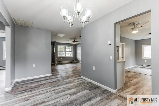 interior space with baseboards, baseboard heating, and wood finished floors