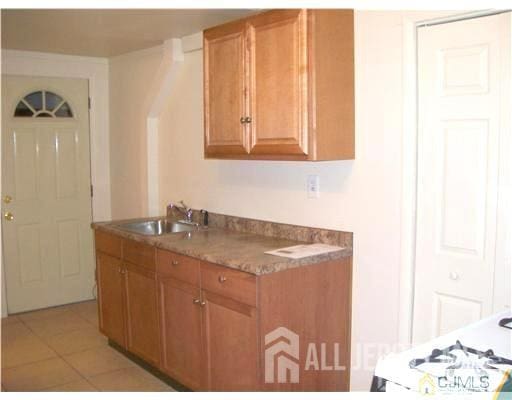 19 Haag St, Sayreville, NJ 08872 - kitchen featuring brown cabinets and light tile patterned floors