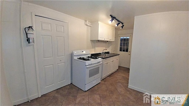 19 Haag St, Sayreville, NJ 08872 - kitchen featuring white range with gas cooktop, dark tile patterned floors, white cabinetry, and track lighting