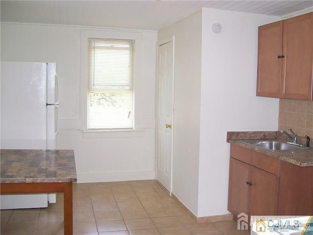 19 Haag St, Sayreville, NJ 08872 - kitchen with brown cabinets, light tile patterned floors, tasteful backsplash, and freestanding refrigerator