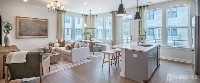 kitchen featuring dark wood-style floors, gray cabinetry, a wealth of natural light, and a sink