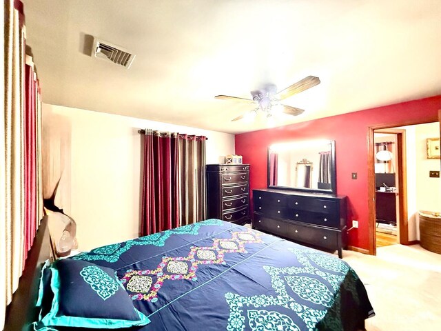 carpeted bedroom with visible vents and ceiling fan