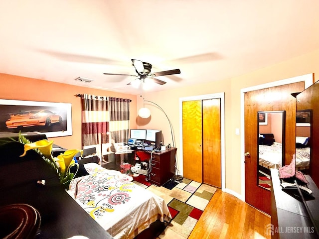 bedroom featuring visible vents, a ceiling fan, and wood finished floors