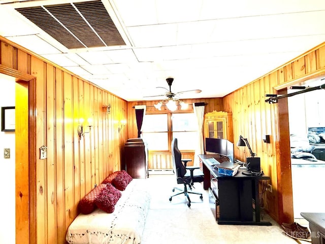 home office with visible vents, wooden walls, a baseboard heating unit, and a ceiling fan