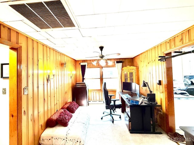 home office featuring a baseboard heating unit, a ceiling fan, visible vents, and wooden walls