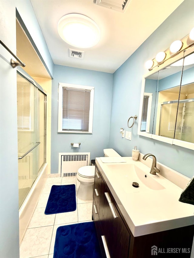 bathroom with radiator, toilet, tile patterned flooring, and a shower with shower door