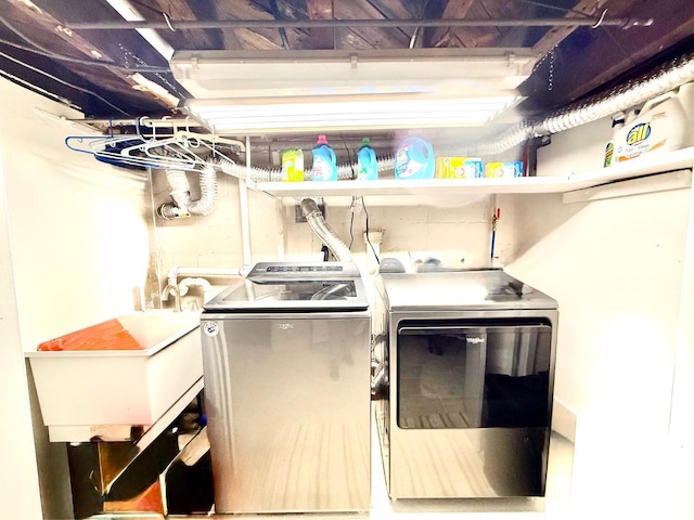 washroom with washing machine and clothes dryer, laundry area, and a sink