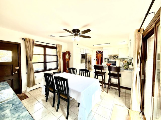 dining space with a baseboard radiator, visible vents, a ceiling fan, and light tile patterned floors