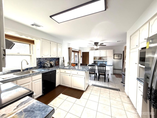 kitchen with tasteful backsplash, a sink, black appliances, a peninsula, and visible vents