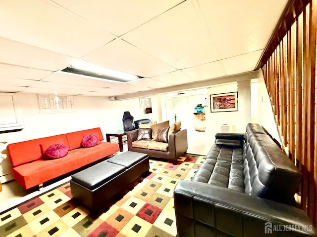 interior space with a baseboard heating unit, tile patterned floors, and a drop ceiling