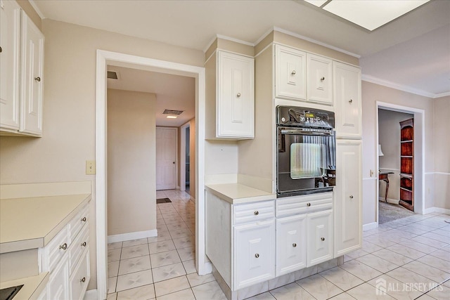 kitchen featuring visible vents, light countertops, marble finish floor, black oven, and white cabinetry
