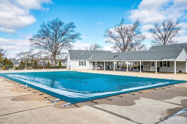 community pool with a patio and fence