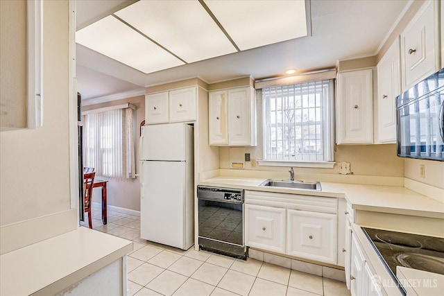 kitchen featuring a sink, white cabinets, freestanding refrigerator, and dishwasher