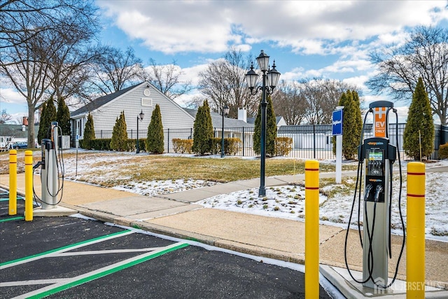 surrounding community featuring fence and uncovered parking