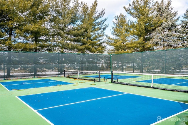 view of tennis court with community basketball court and fence