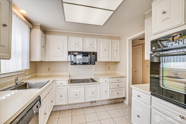 kitchen featuring a sink, light tile patterned floors, light countertops, black appliances, and white cabinetry