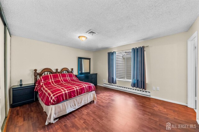 209-A Vernon Rd, Monroe, NJ 08831 - bedroom with a baseboard radiator, wood finished floors, baseboards, and a textured ceiling