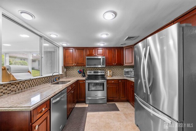 209-A Vernon Rd, Monroe, NJ 08831 - kitchen featuring stainless steel appliances, a sink, decorative backsplash, light stone counters, and light tile patterned floors