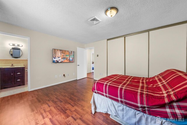 209-A Vernon Rd, Monroe, NJ 08831 - bedroom featuring wood finished floors, a closet, ensuite bath, a textured ceiling, and a sink