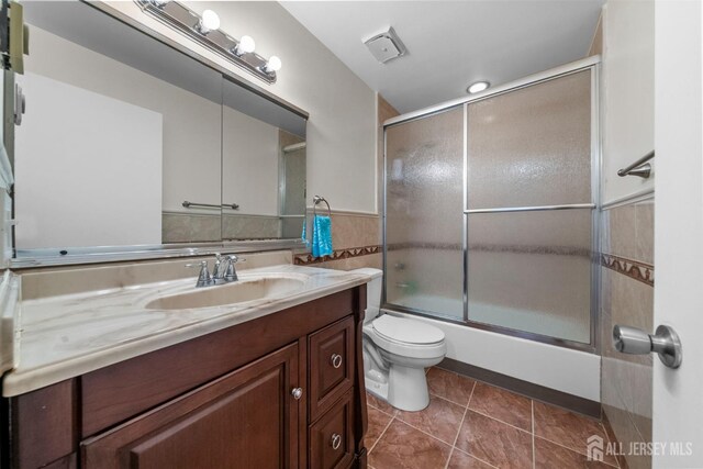 209-A Vernon Rd, Monroe, NJ 08831 - bathroom featuring vanity, toilet, tile patterned flooring, enclosed tub / shower combo, and a wainscoted wall