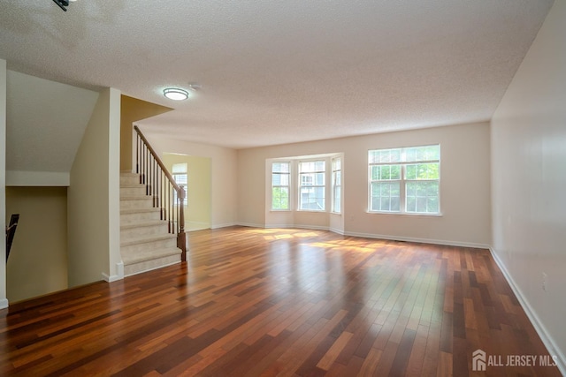 85 W Shrewsbury Pl, Princeton, NJ 08540 - unfurnished living room with hardwood / wood-style flooring, stairway, baseboards, and a textured ceiling