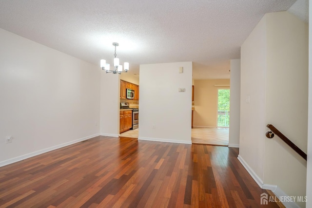 85 W Shrewsbury Pl, Princeton, NJ 08540 - empty room with a chandelier, dark wood-style floors, a textured ceiling, and baseboards
