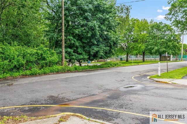 111 E 5th Ave, Port Reading, NJ 07064 - view of asphalt street with curbs and view of wooded area