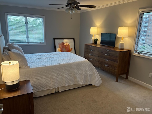 bedroom with crown molding, baseboards, carpet floors, and ceiling fan