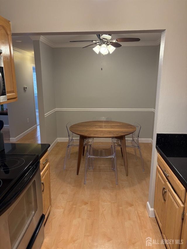 dining room featuring crown molding, ceiling fan, light wood finished floors, and baseboards