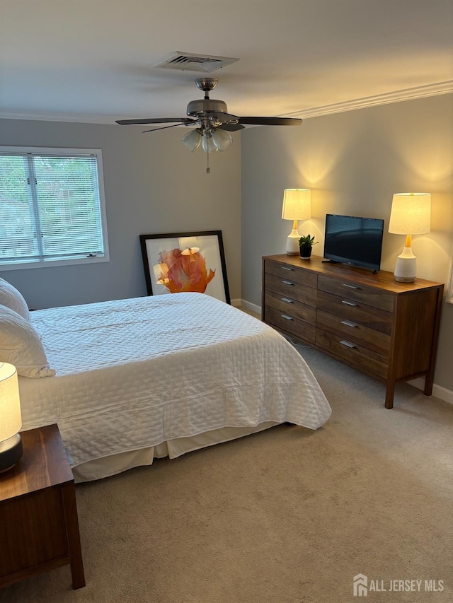 carpeted bedroom with ornamental molding, baseboards, and a ceiling fan