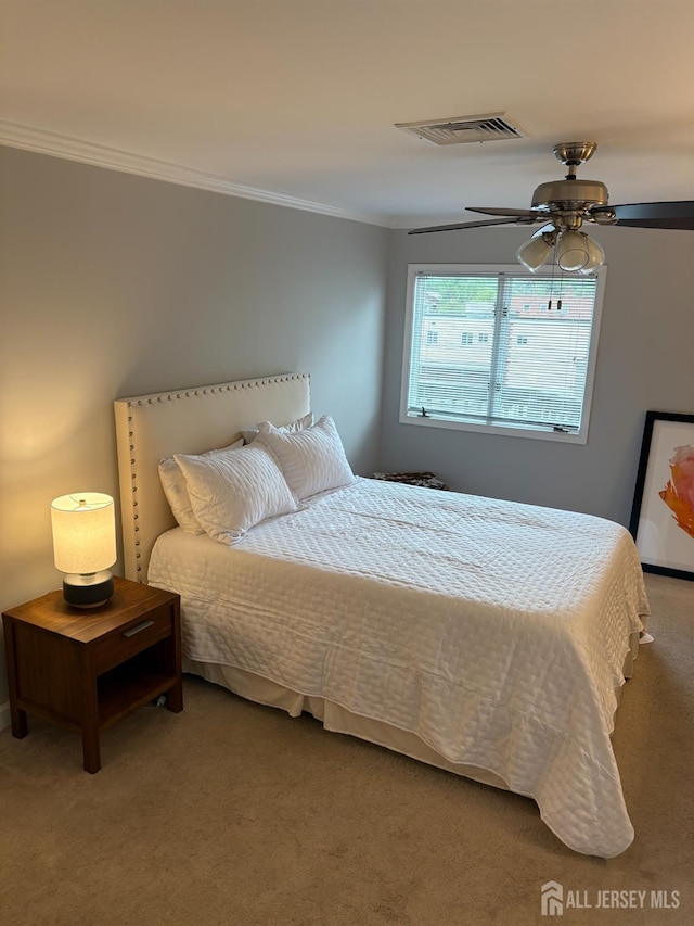 bedroom with ornamental molding and carpet