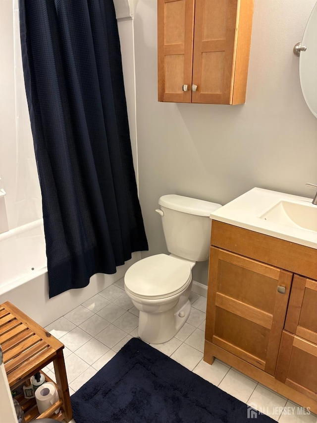 full bath with toilet, tile patterned floors, baseboards, and vanity