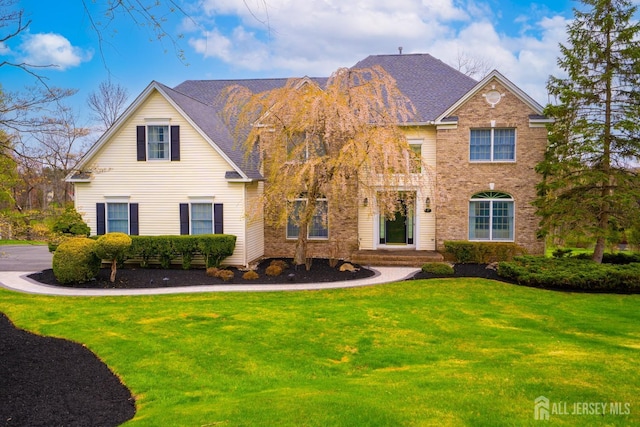 view of front of property featuring brick siding and a front yard