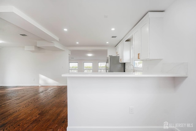 2 Buttonwood Dr, Parlin, NJ 08859 - kitchen with freestanding refrigerator, white cabinetry, dark wood finished floors, a peninsula, and open floor plan