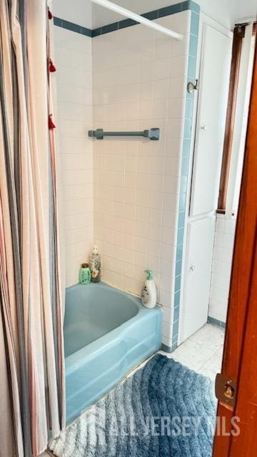 full bathroom with shower / bath combo with shower curtain and tile patterned floors