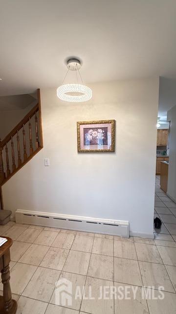 interior space featuring stairway, baseboard heating, and light tile patterned floors