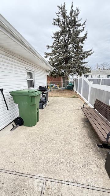 view of patio / terrace with a grill and fence