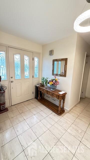 entrance foyer featuring light tile patterned floors and baseboards