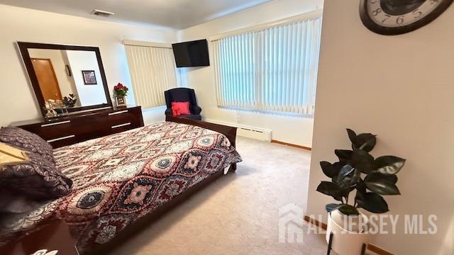 carpeted bedroom with baseboards, visible vents, and baseboard heating