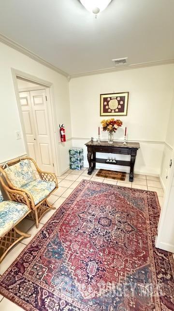 living area with ornamental molding, visible vents, and tile patterned floors