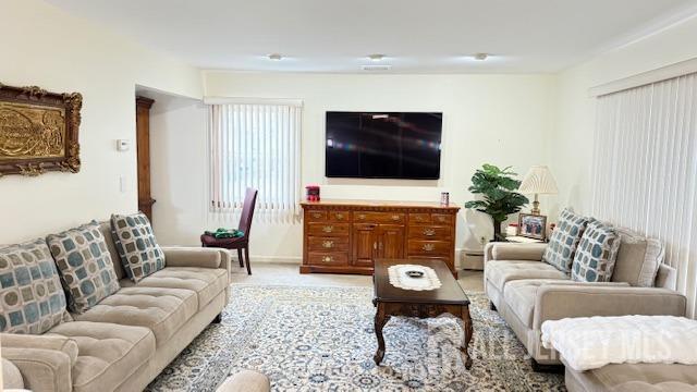 living area with light carpet and baseboard heating