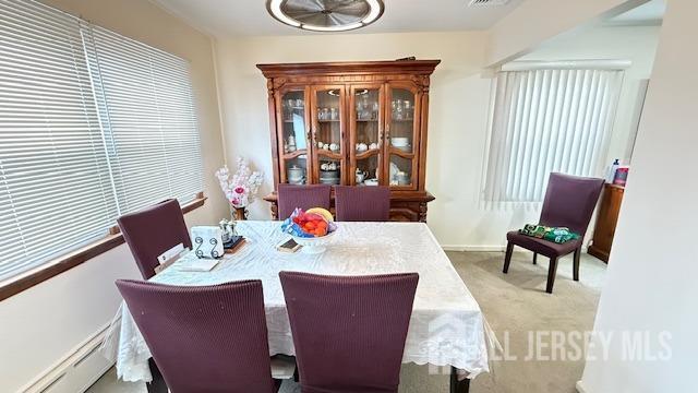 dining area with a baseboard heating unit, visible vents, and carpet floors