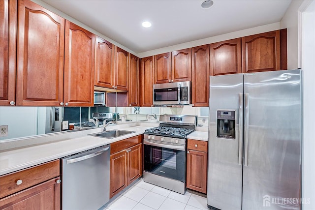 78 Central Ave Unit 49, Metuchen, NJ 08840 - kitchen with appliances with stainless steel finishes, a sink, light tile patterned floors, brown cabinetry, and recessed lighting