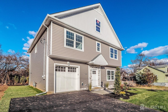 view of front of property featuring driveway, an attached garage, and a front yard